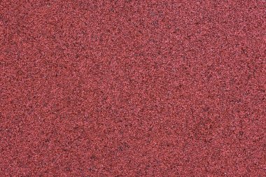 Kırmızı spor alanı lastik kaplaması makro manzarayı kapatıyor. Oyun alanı kaldırım döşemesi dokusu son derece yakın.