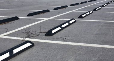 Beyaz çizgileri ve kaldırımları olan boş park yeri.