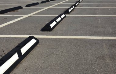 Beyaz çizgileri ve kaldırımları olan boş park yeri.