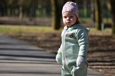 Nane kokulu, yumuşak kabuklu bebek baharda bir parkta yürüyor. Güneşli bir günün dışında gülümseyen bebek portresi.