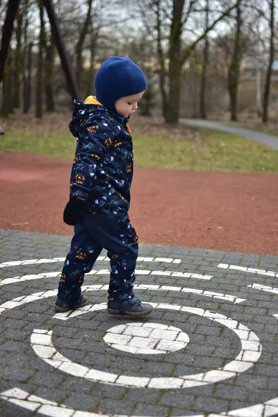 Küçük çocuk baharda çocuk parkında oynuyor. Çocuk baharda parkta eğleniyor..