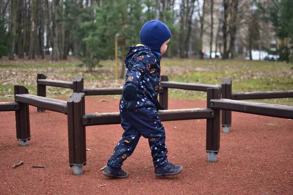 Küçük çocuk baharda çocuk parkında oynuyor. Çocuk baharda parkta eğleniyor..