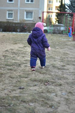 Sovyet tarzında oynayan küçük bir kız çocuğu soğuk havada çocuk parkında oynuyor. Küçük kız kışın halk parkında eğleniyor..