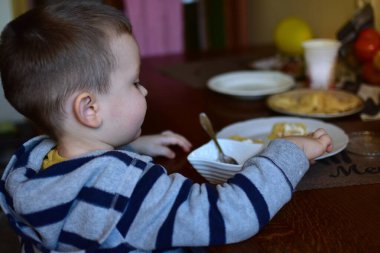 Küçük çocuk kahvaltıda gözleme yiyor evde. Çocuk lezzetli yemek yiyor..