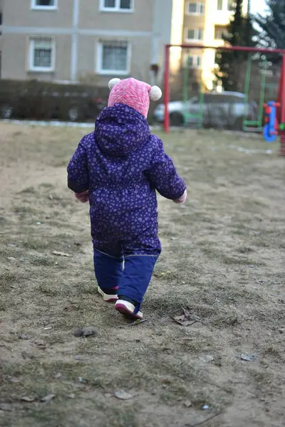 Sovyet tarzında oynayan küçük bir kız çocuğu soğuk havada çocuk parkında oynuyor. Küçük kız kışın halk parkında eğleniyor..