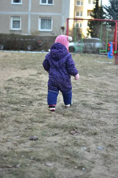 Sovyet tarzında oynayan küçük bir kız çocuğu soğuk havada çocuk parkında oynuyor. Küçük kız kışın halk parkında eğleniyor..