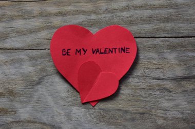 Mesaj metni, kırmızı kalp şeklindeki kart üzerindeki sevgililer günü için ahşap ahşap desenli arka planda olacak. Sevgililer günü kartında sözcükler benim sevgilim olsun. Minimalist Sevgililer Günü.