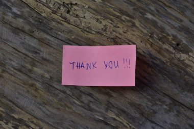 Tahta döşemeli arka planda pembe yapışkan not gününde teşekkür ederim.