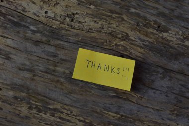 Tahta döşemeli arka planda sarı yapışkan not gününde teşekkür ederim.