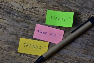 Mesaj için teşekkür ederim. Pembe yeşil ve sarı yapışkan notlar için teşekkür ederim. Tahta ahşap arka planda, sürdürülebilir kağıt kalemin yanında..