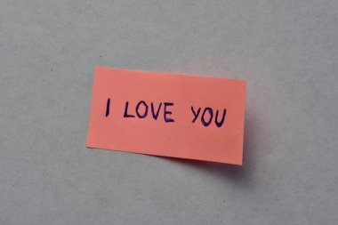 Beyaz karton arka planda sevgililer günü için pembe notta seni sevdiğimi söyle.