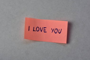 Beyaz karton arka planda sevgililer günü için pembe notta seni sevdiğimi söyle.