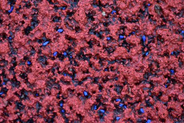 Kırmızı spor alanı lastik kaplaması makro manzarayı kapatıyor. Oyun alanı kaldırım döşemesi dokusu son derece yakın.