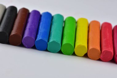 Renkli kil çubuklar beyaz arkaplanda hamur plastiklerinin canlı renklerini çalar