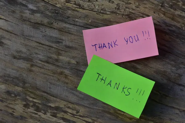 Mesaj için teşekkür ederim. Pembe ve yeşil notlar için teşekkür ederim. Tahta döşemeli arka planda.