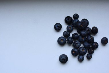 Taze yaban mersinleri beyaz masaya yayılır.