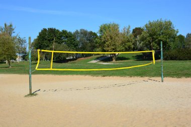 Açık havada boş plaj voleybolu sahası, güneşli yaz günlerinde direkler ve parktaki ağlar..