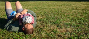 Babası güneşli bir günde kırsalda küçük kızıyla oynuyor. Kırsal kesimde çimlerin üzerinde eğlenceli aile zamanları..