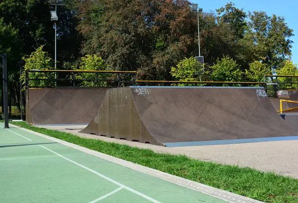 Güneşli yaz gününde boş bir kaykay parkı. Atlama ve numaralar için çocuksuz kaykay rampaları.