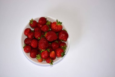 Beyaz arka plan manzaralı taze çilek kasesi. Bir kase kırmızı sulu çilek..