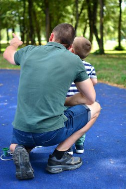 Baba dizlerinin üstünde oğluna park konseptinde kuşları gösteriyor. Baba ve oğul oyun parkında hayvanları gözlemliyor. Babası ve oğlu şehirdeki halk parkında oynuyorlar. Yüzü yok