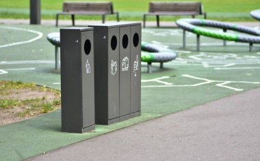 Kamu parkında plastik, kağıt, cam ve genel atık için ayrı konteynırlar bulunan çöp kutularının sıralanması sürdürülebilirliği ve sorumlu geri dönüşüm alışkanlıklarını teşvik eder.