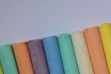 Pastel renkli tebeşir çubuklarının köşegen şeklinde yakın plan görüntüsü. Eğitim, yaratıcılık veya kavram çizen çocuklar için uygun sanatsal doku ve renk çeşitliliği.