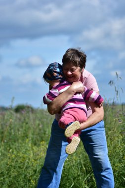 Neşeli bir büyükanne, torununu sıcak bir yaz tarlasında kucağına alıyor. Aşk, aile bağı ve tasasız çocukluk güzel bir şekilde yakalandı..