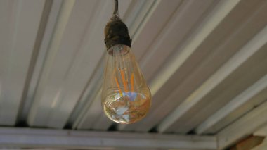 Çatı kiremitlerinin arkaplanı ile yakın plan çekilmiş bir lamba