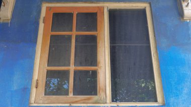 Mavi duvarlı cam bir pencere.