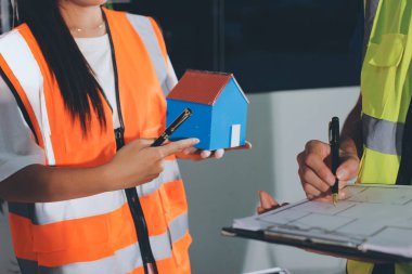 Endüstriyel mühendislerden oluşan bir ekip, fabrikadaki masada bulunan makine planlarını analiz ediyor. Fabrikada ya da üretim tesisinde çalışıyorum..