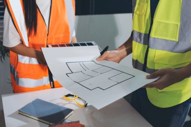 Endüstriyel mühendislerden oluşan bir ekip, fabrikadaki masada bulunan makine planlarını analiz ediyor. Fabrikada ya da üretim tesisinde çalışıyorum..