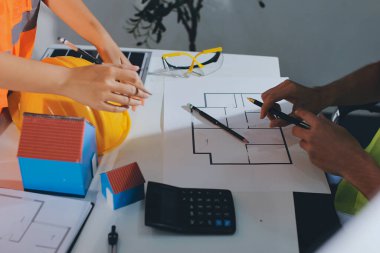 Endüstriyel mühendislerden oluşan bir ekip, fabrikadaki masada bulunan makine planlarını analiz ediyor. Fabrikada ya da üretim tesisinde çalışıyorum..