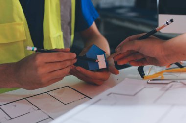 Endüstriyel mühendislerden oluşan bir ekip, fabrikadaki masada bulunan makine planlarını analiz ediyor. Fabrikada ya da üretim tesisinde çalışıyorum..