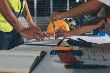 Endüstriyel mühendislerden oluşan bir ekip, fabrikadaki masada bulunan makine planlarını analiz ediyor. Fabrikada ya da üretim tesisinde çalışıyorum..