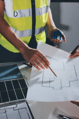 Endüstriyel mühendislerden oluşan bir ekip, fabrikadaki masada bulunan makine planlarını analiz ediyor. Fabrikada ya da üretim tesisinde çalışıyorum..