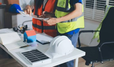 Endüstriyel mühendislerden oluşan bir ekip, fabrikadaki masada bulunan makine planlarını analiz ediyor. Fabrikada ya da üretim tesisinde çalışıyorum..