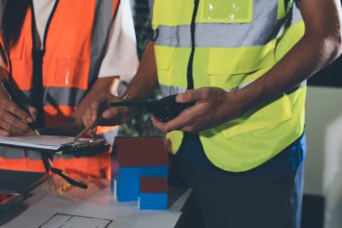 Endüstriyel mühendislerden oluşan bir ekip, fabrikadaki masada bulunan makine planlarını analiz ediyor. Fabrikada ya da üretim tesisinde çalışıyorum..