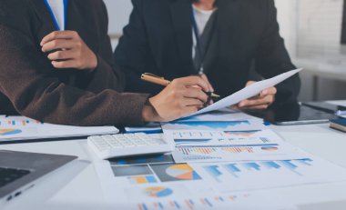 Gözlüklü yetenekli bir avukatla anlaşma imzalamaya odaklanmış genç bir işadamı. Konsantre mali danışman, ofiste erkek müşteriye sözleşme belgesinde imza yeri gösteriyor.