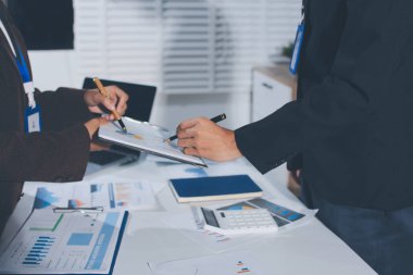 Gözlüklü yetenekli bir avukatla anlaşma imzalamaya odaklanmış genç bir işadamı. Konsantre mali danışman, ofiste erkek müşteriye sözleşme belgesinde imza yeri gösteriyor.