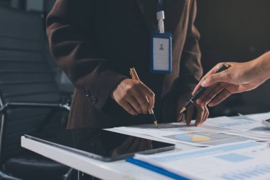 Gözlüklü yetenekli bir avukatla anlaşma imzalamaya odaklanmış genç bir işadamı. Konsantre mali danışman, ofiste erkek müşteriye sözleşme belgesinde imza yeri gösteriyor.