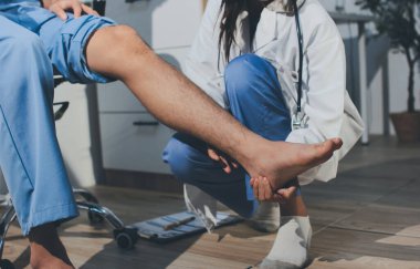 Fizyoterapist hastaya diz ağrısı için egzersiz yapmayı öğretiyor.