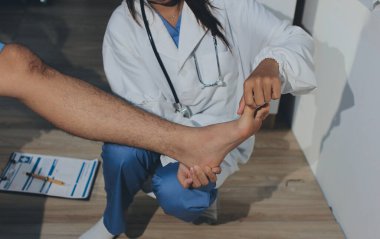 Fizyoterapist hastaya diz ağrısı için egzersiz yapmayı öğretiyor.