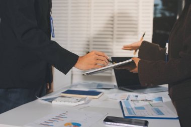 Gözlüklü yetenekli bir avukatla anlaşma imzalamaya odaklanmış genç bir işadamı. Konsantre mali danışman, ofiste erkek müşteriye sözleşme belgesinde imza yeri gösteriyor.