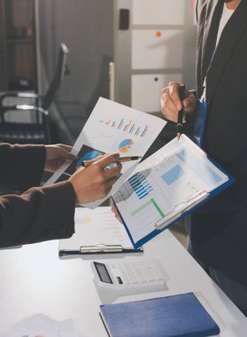 Gözlüklü yetenekli bir avukatla anlaşma imzalamaya odaklanmış genç bir işadamı. Konsantre mali danışman, ofiste erkek müşteriye sözleşme belgesinde imza yeri gösteriyor.