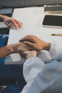 Doktor hastayı kontrol etmeye geldi ve cesaretlendirmek için elini sıktı. Hastanede tedavi edilenleri ve hastaları teselli etmek..