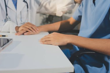 Doktor hastayı kontrol etmeye geldi ve cesaretlendirmek için elini sıktı. Hastanede tedavi edilenleri ve hastaları teselli etmek..