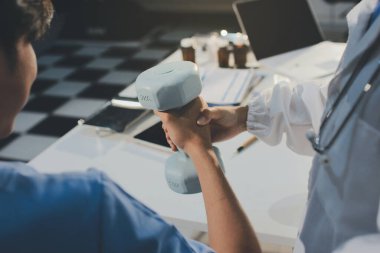 Hemşirenin desteğiyle el ağırlığı kullanan kişi