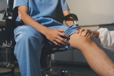 Fizyoterapist hastaya diz ağrısı için egzersiz yapmayı öğretiyor.