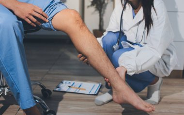 Fizyoterapist hastaya diz ağrısı için egzersiz yapmayı öğretiyor.